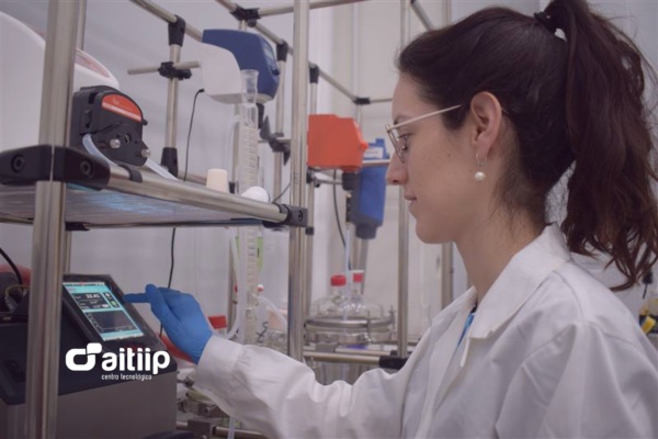 Investigadora de Aitiip, centro tecnológico especializado en innovación y ciencia, operando un equipo de análisis con pantalla táctil en laboratorio de investigación industrial.